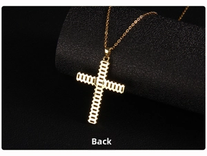 Macro view of the textured back side of a gold plated cross pendant on a link chain