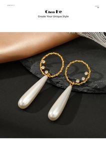 Detail view of twisted gold earrings with white rhinestones and a water drop pearl drop