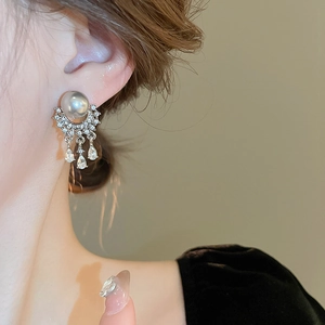 Close-up of vintage tassel earrings with gray pearls and water-drop zircon pendants
