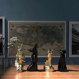 Detailed set of Anubis and Bastet statues in gold and matte black finish on wood