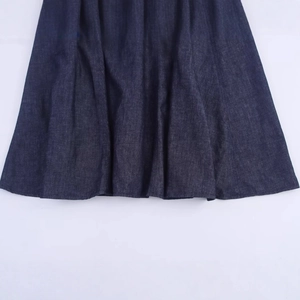 Gros plan d'une robe midi en denim bleu foncé montrant la texture et les coutures