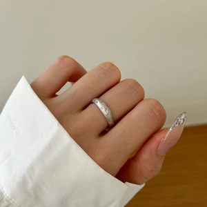 Close-up of S925 sterling silver ring featuring a matte finish and starburst engraving
