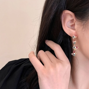 Close-up of elegant gold long tassel butterfly earrings with colorful zircons on a model