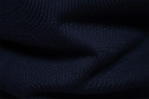 Gros plan sur la maille de coton bleu foncé montrant la texture douce et les finitions
