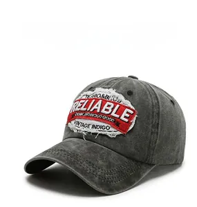 Detail of vintage gray washed cotton baseball cap with red embroidered logo patch