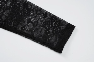 Detailaufnahme des schwarzen Netzkleides mit floralen Spitzenstrukturen und Mustern
