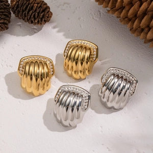 Textured gold and silver fan-shaped earrings with diamond accents on a white surface
