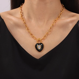Collana a catena dorata 18k con pendente a cuore nero in zircone indossata da una modella