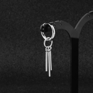 Macro shot of polished stainless steel hoop earrings with three vertical pillar charms