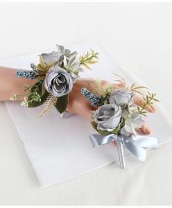 Detail of vintage dusty blue rose boutonniere and wrist corsage set on white display