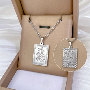 Detail of gold titanium steel pendant with Fu character and embossed dragon pattern