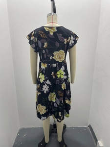 Detail of floral tiered cake dress with fluttering sleeves and summer print texture