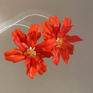 Oversized bright orange acrylic flower earrings with glossy finish and silver needle