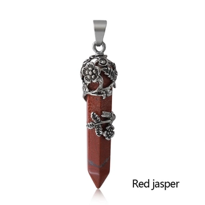 Detail of red jasper hexagonal pendant with vintage silver floral relief and metal hook