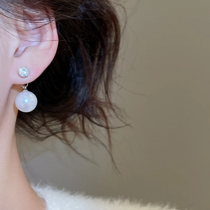 Detail shot of a model wearing a minimalist silver pearl earring with a sparkling zircon stud