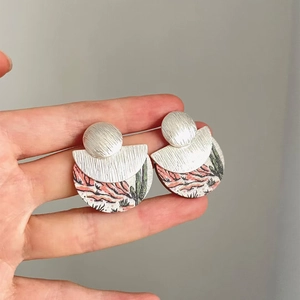 Détail de boucles d'oreilles bohèmes avec métal brossé et motifs de cactus