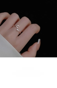 Close-up of adjustable silver ring featuring a crystal-paved letter C and a single diamond