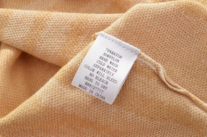 Dettaglio dell'etichetta di lavaggio che mostra la composizione 70% rayon e 30% nylon