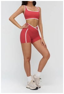 Detail of red yoga set showing white contrast piping and V-shape crossover waistband