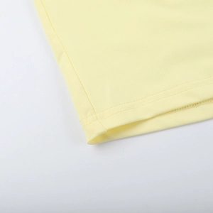 Detailansicht des gelben Strickkleid-Saums mit präziser Nahtführung und feiner Textur