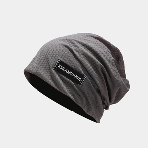 Detail of dark grey breathable mesh knit beanie with black rectangular logo patch