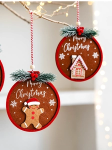 Detail of felt gingerbread man and house ornaments with red piping on Christmas tree