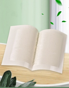 Detailed view of beige hydrogel neck patch on a wooden surface with green leaf accents