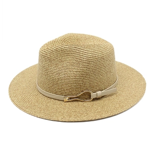 Detailed close-up of woven panama straw hat texture with cream belt and gold buckle