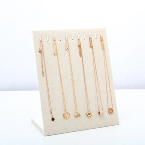 Microfiber jewelry display stand with rose gold elephant and crown pendant necklaces
