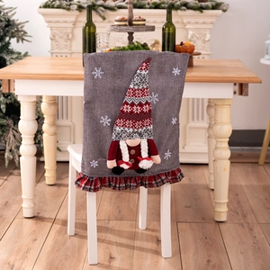 Detail of Christmas gnome chair cover with 3D plush doll and red plaid ruffle hem