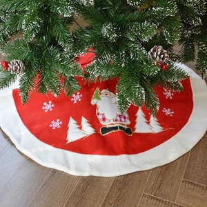 Classic red Christmas tree skirt with plush white edge and Santa Claus festive pattern