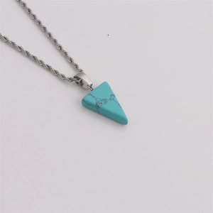 Vue rapprochée d'une chaîne torsadée argentée avec pendentif turquoise en triangle