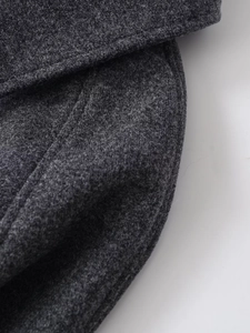 Close-up of the high-quality dark grey wool blend fabric texture of the short coat