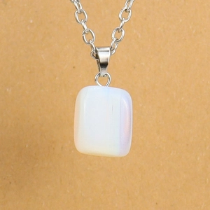Detailed view of an iridescent white crystal stone pendant on a silver link chain