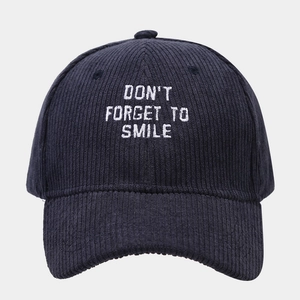Navy corduroy baseball cap with 'Don't Forget To Smile' white embroidery on a gray background