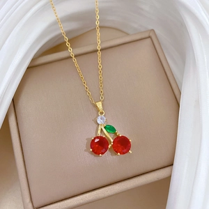 Detail of elegant cherry pendant necklace with red crystals on a luxury jewelry box