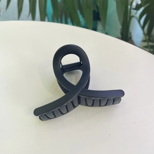 Gros plan d'une pince à cheveux torsadée noire mate avec design antidérapant élégant