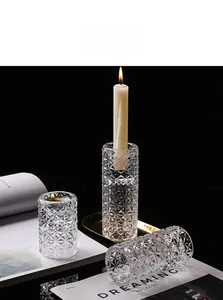 Detailed macro shot of geometric faceted clear glass candle holders on a dark elegant setting