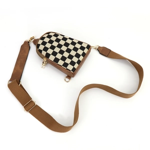 Vue de dessus d'un sac bandoulière à damier avec garniture en cuir brun et fermoirs dorés
