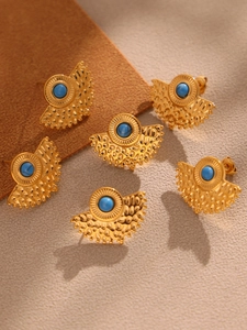 Macro view of gold peacock fan earrings with turquoise beads and hammered texture detail