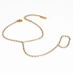 Détail du bracelet bague en acier inoxydable doré avec perles sur fond blanc épuré