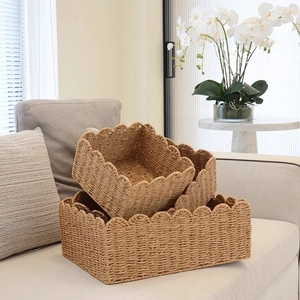 Natural woven storage baskets set with wavy lace edges on a grey sofa for home decor