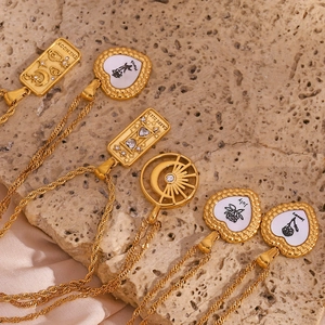 Detailed view of 18K gold heart and rectangle tarot pendants on vintage twist chains