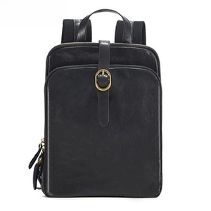 Macro shot of high-quality black leather texture and golden round buckle on the backpack