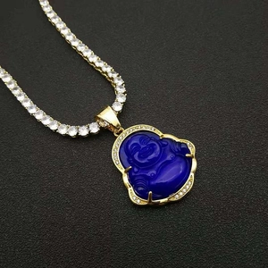 Macro view of gold-plated Buddha pendant with blue stone and sparkling crystal inlay