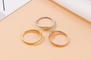 Detailed view of minimalist wave rings in silver, gold, and rose gold finishes
