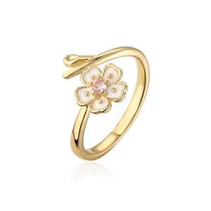 Macro shot of gold-plated cherry blossom open ring with pink zircon and white petals