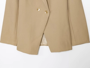 Detail of khaki double-breasted blazer showing twill texture and overlapping hem design