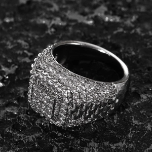 Macro shot of men's iced out hip hop ring with cubic zirconia on black volcanic stone
