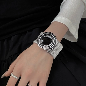 Detail of chunky silver spiral cuff bracelet with large black faceted resin stone